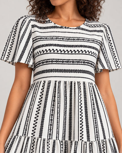 Close-up of neckline, patterned bodice, flutter sleeves, waist seam and tiers of the Black variant dress